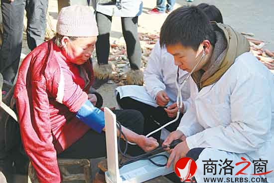 愛心社區人員幫老人量血壓