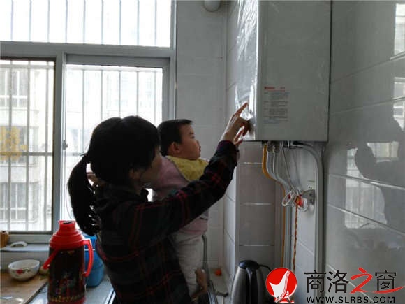 家住市區香菊小區的李女士正在操作自家剛剛安裝的燃氣壁掛爐，提升室內的溫度。