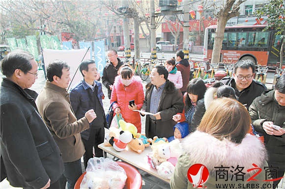 元宵節當天，報社領導走上街頭為安裝“掌中商洛”的讀者發放禮品。