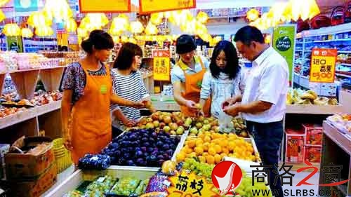 環境優美的水果專賣店里,店員耐心地幫著顧客挑選水果。